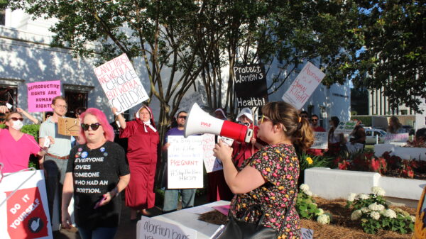 woman at megaphone chanting during statehouse protest