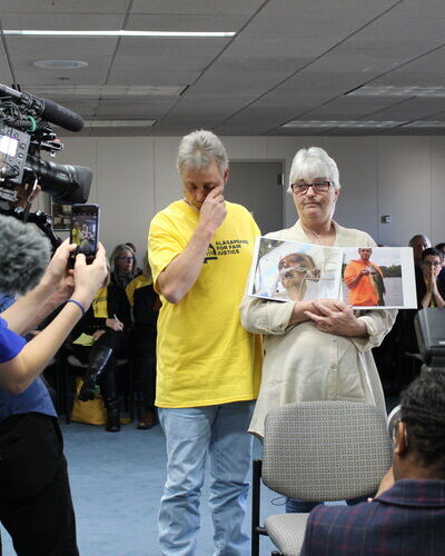 Sandy Davis holds picture of son in front of media