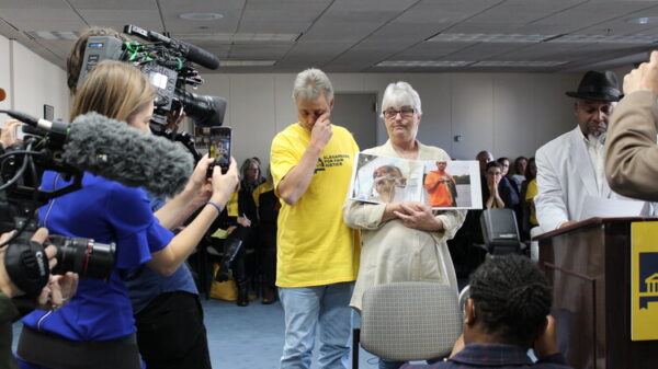 Sandy Davis holds picture of son in front of media