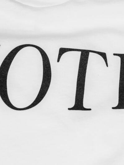 A photo of a white textured background with black text that reads "Vote". Photo was taken by Cyrus Crossan