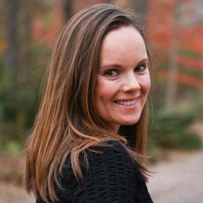 Headshot of a white woman with brown hair wearing a black shirt