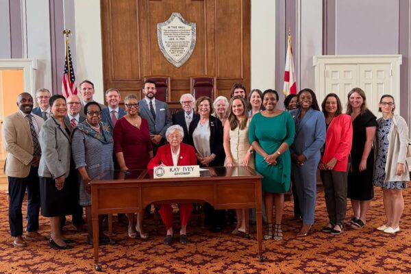 group posed with Governor Kay Ivey signing the Maternal Healthcare Act Bill Signing