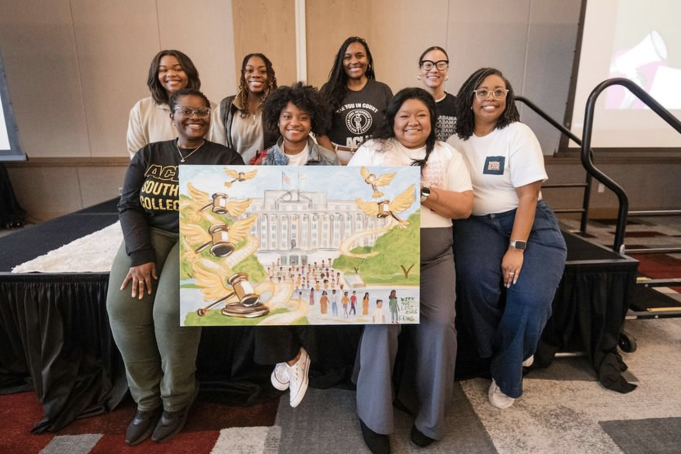 aclu of alabama staff hold a painting from our legislative training event