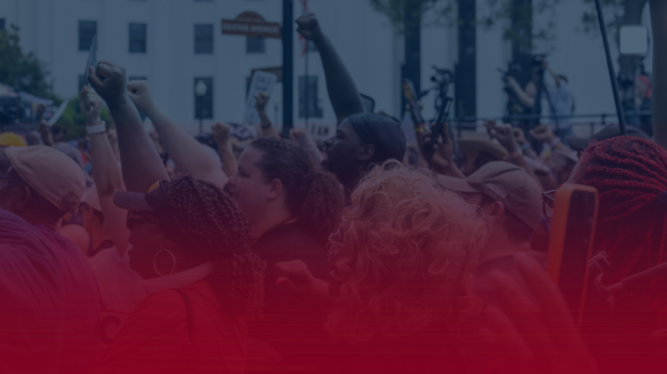 image of people with fists raised on a blue field with a red gradient coming up from the bottom