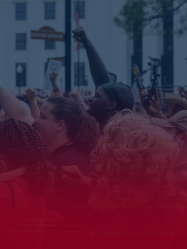 image of people with fists raised on a blue field with a red gradient coming up from the bottom