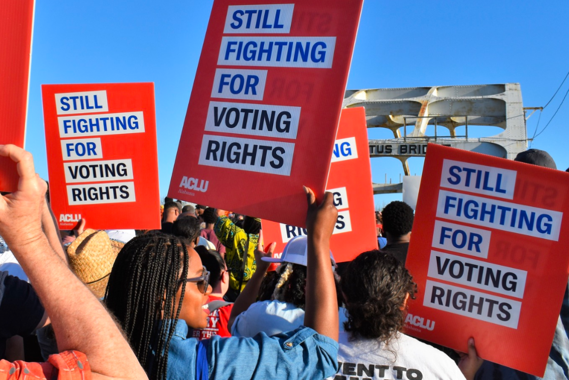 People holding signs that state "Still Fighting For Voting Rights" during the Selma Jubilee