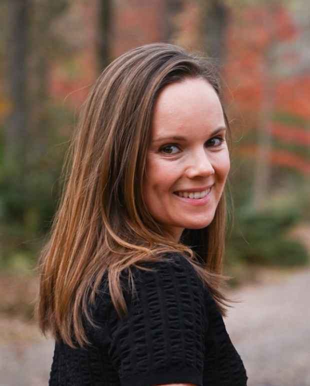 Headshot of a white woman with brown hair wearing a black shirt