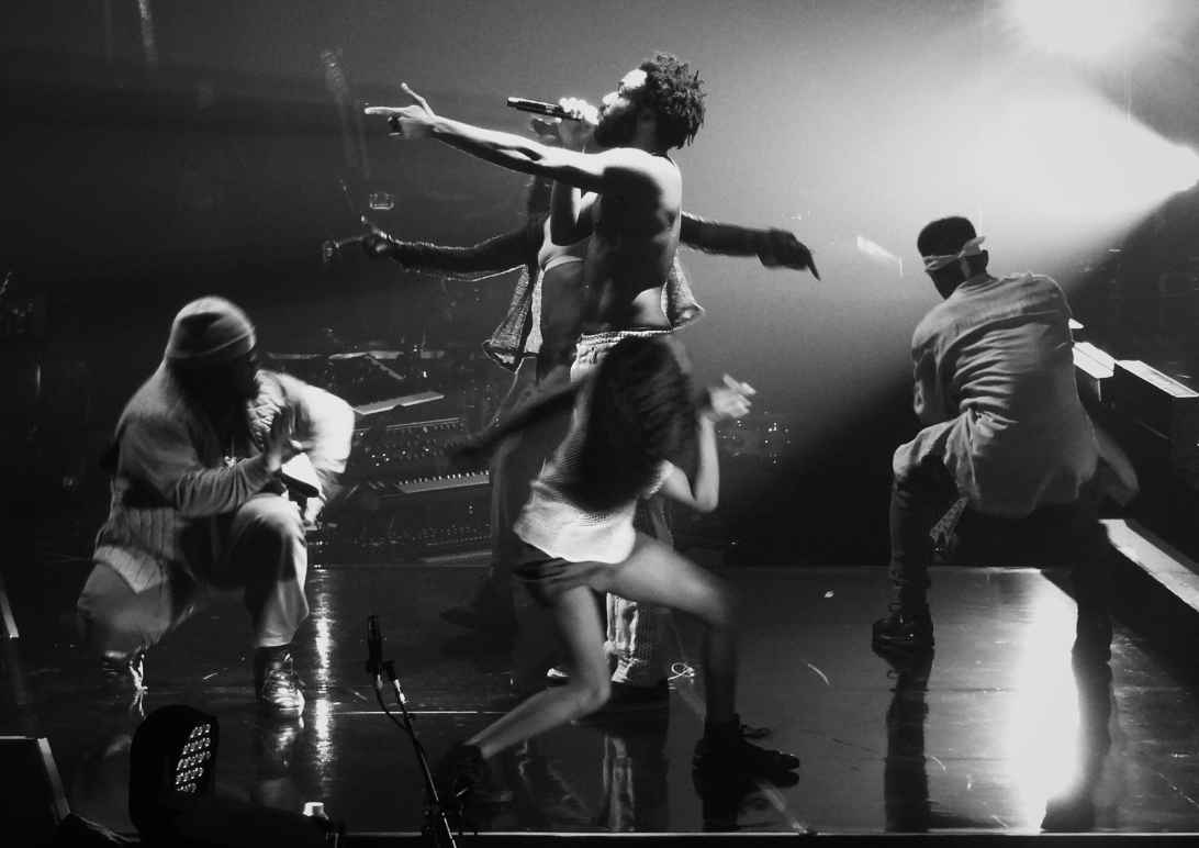 childish gambino performing "this is america" on stage, surrounded by dancers