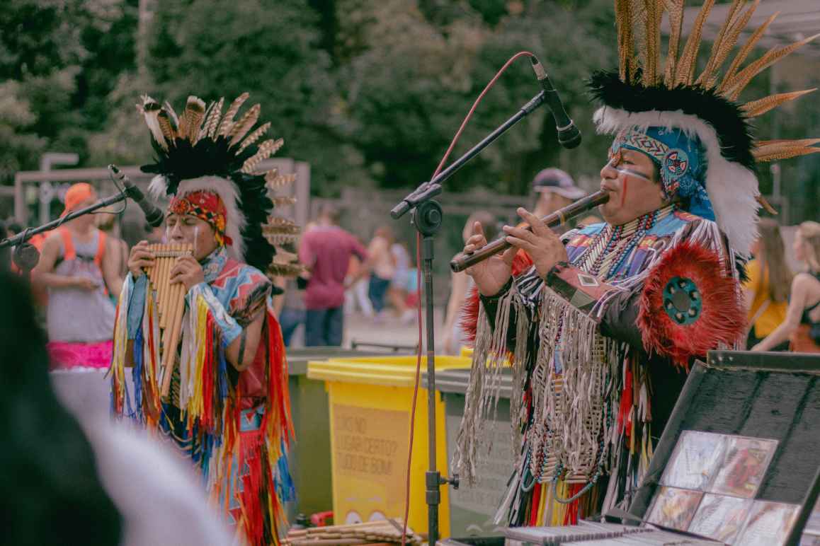 Photo of two Native Americans playing woodwind instruments