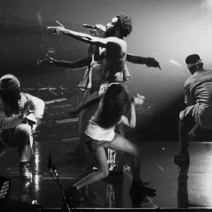 childish gambino performing "this is america" on stage, surrounded by dancers