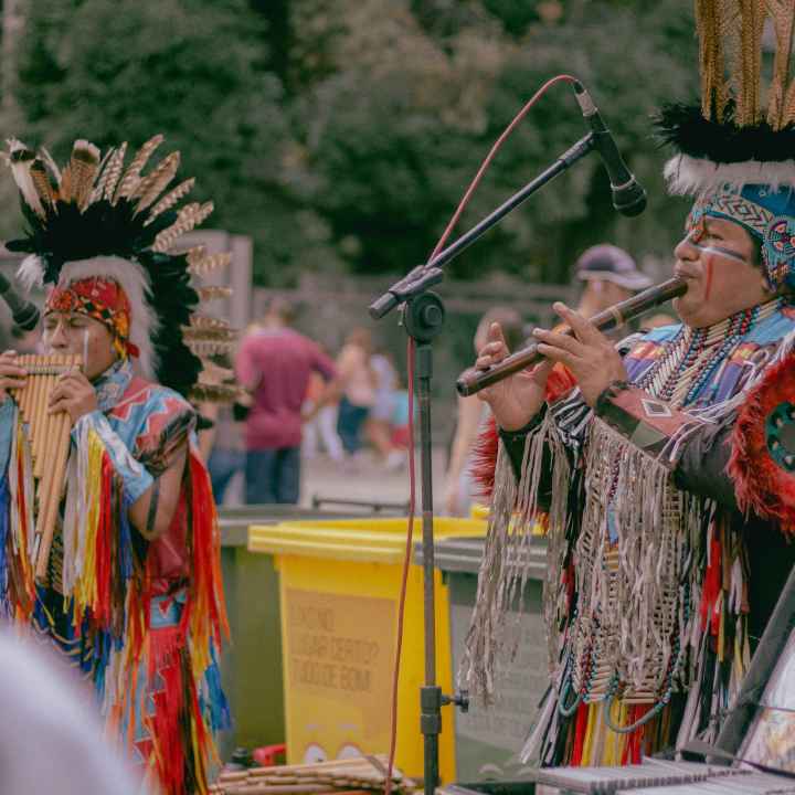 Photo of two Native Americans playing woodwind instruments